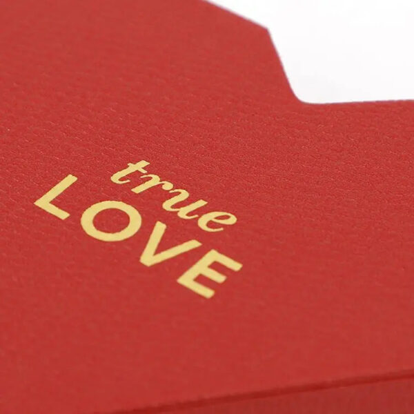 Textured Red Heart-Shaped Rigid Box with Gold Foil Logo Textured Red Heart-Shaped Rigid Box with Gold Foil Logo