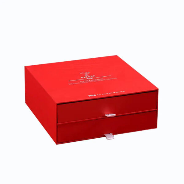 Closed red rigid skincare serum gift box with two stacked drawers and ribbon pull tabs