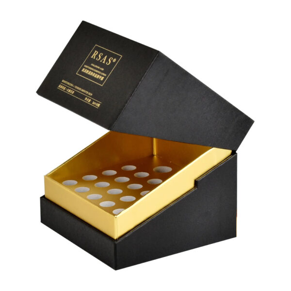 Side-angle view of open rigid serum ampoule packaging with hinged lid and fitted gold insert