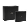 Two closed black rigid presentation boxes in different sizes with gold logos