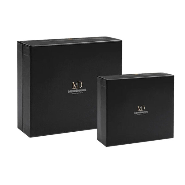 Two closed black rigid presentation boxes in different sizes with gold logos