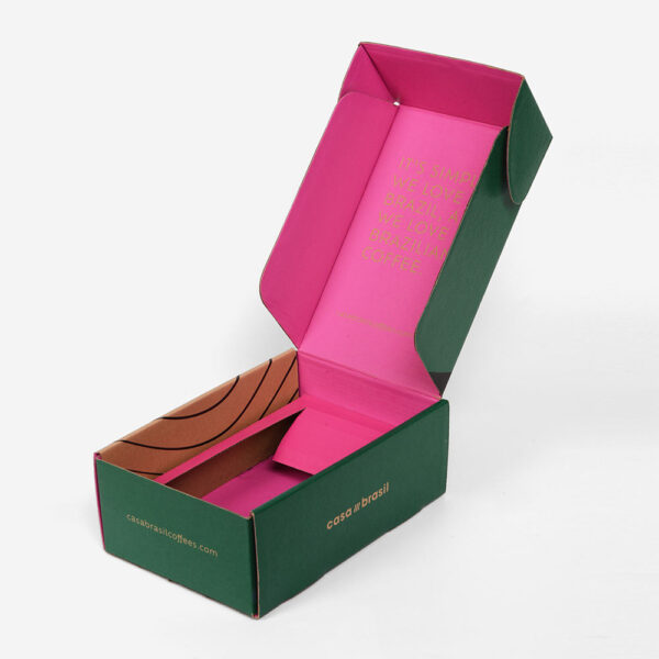 Caja de cartón ondulado verde y rosa para enviar café por correo, con inserto
