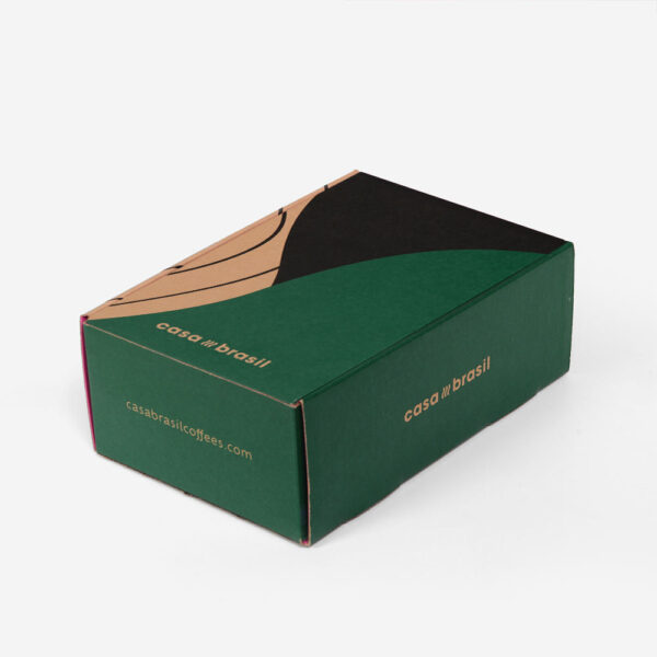 Caja de cartón ondulado verde y rosa para enviar café por correo, con inserto