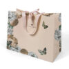 Hand holding blush paper gift bag