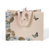 Hand holding blush paper gift bag