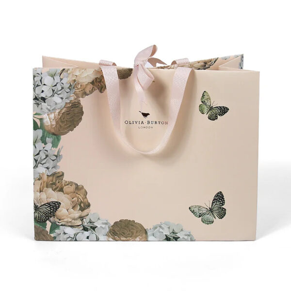Hand holding blush paper gift bag