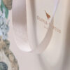 Hand holding blush paper gift bag