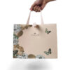 Hand holding blush paper gift bag