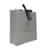 Ivory Paper Shopping Bag with Black Ribbon Bow and Gold Logo